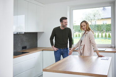 Couple examining kitchen in new flat - ABIF00440