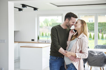 Man kissing pregnant woman in empty flat - ABIF00442