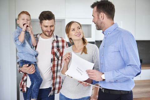 Family and real estate agent talking in new apartment stock photo