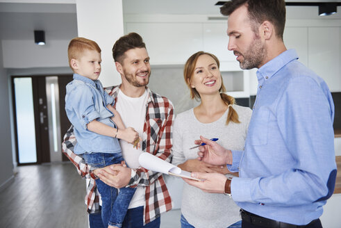 Familie und Immobilienmakler im Gespräch in der neuen Wohnung - ABIF00457