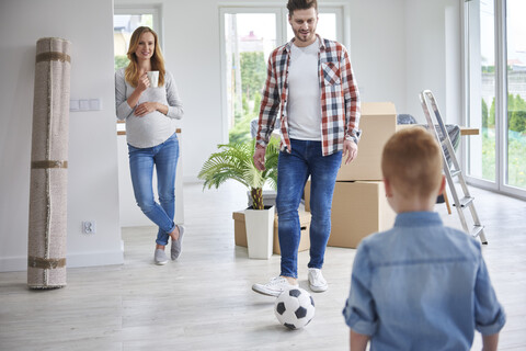 Family playing football in new flat stock photo