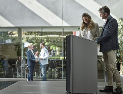 Smiling colleagues standing on stage at lectern - CVF00585