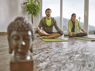 Couple practicing yoga in a room with panorama window - CVF00597