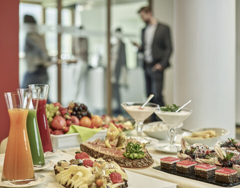 Buffet mit Vorspeisen und Geschäftsleuten im Hintergrund, lizenzfreies Stockfoto