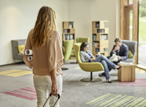 Businesswoman arriving with trolley suitcase stock photo