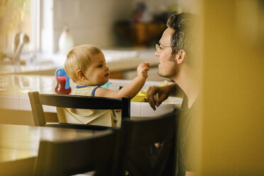 Vater hilft seinem kleinen Sohn beim Essen - ISF02365