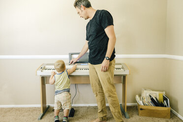 Vater und kleiner Sohn spielen zusammen auf dem Keyboard - ISF02380