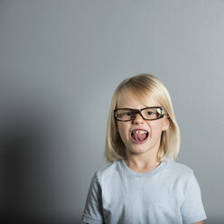 Portrait of boy wearing glasses sticking out tongue - ISF02391