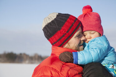 Vater trägt kleinen Sohn in verschneiter Landschaft - ISF02422