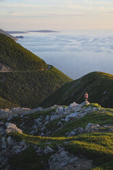 Wanderer auf einem Felsvorsprung, Cape Breton, Nova Scotia, Kanada - ISF02445