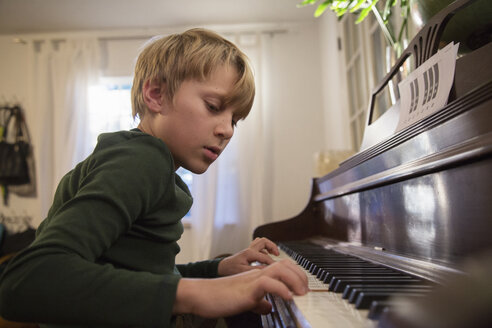 Junge spielt Klavier im Wohnzimmer - ISF02461