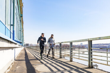 Freunde laufen auf einer Brücke in der Stadt - WPEF00315