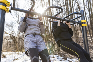 Friends doing chin-ups in a park - WPEF00321