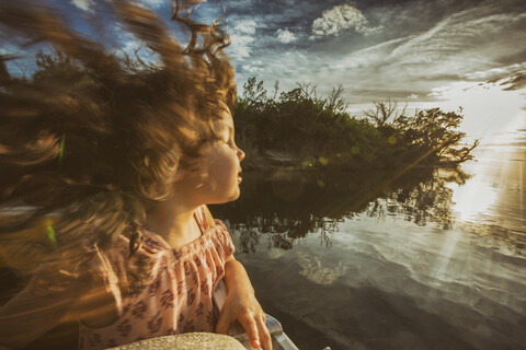 Junges Mädchen genießt die Fahrt auf dem Fluss, die Augen geschlossen und im Sonnenlicht, Homosassa, Florida, USA, lizenzfreies Stockfoto