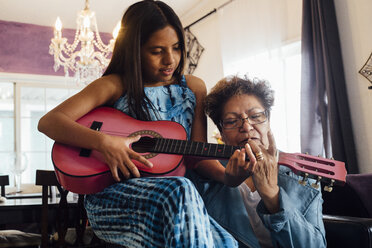 Grandmother teaching granddaughter to play guitar - ISF02536