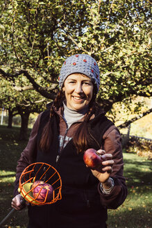 Porträt einer Frau mit Obstpflücker und frischem Apfel - ISF02562