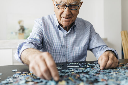 Älterer Mann beim Puzzeln - JRFF01677