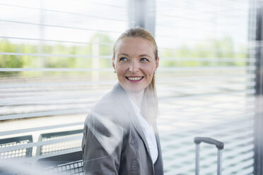 Portrait of smiling mature businesswoman waiting at platform - DIGF04474