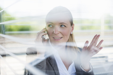 Porträt einer reifen Geschäftsfrau am Telefon, die am Bahnsteig wartet, lizenzfreies Stockfoto