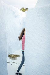 Girl walking behind wall, Oía, Santorini, Kikladhes, Greece - ISF02629