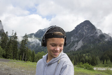 Portrait of teenage boy in rural setting, wearing headphones - ISF02642