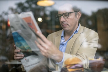 Mann im Café liest Zeitung - ISF02770