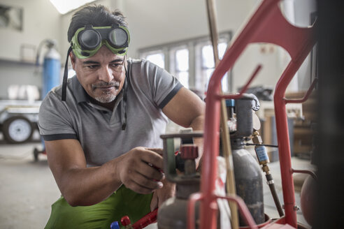 Man preparing welding jig in bodywork repair shop - ISF02773