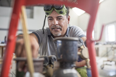 Man preparing welding jig in bodywork repair shop - ISF02774