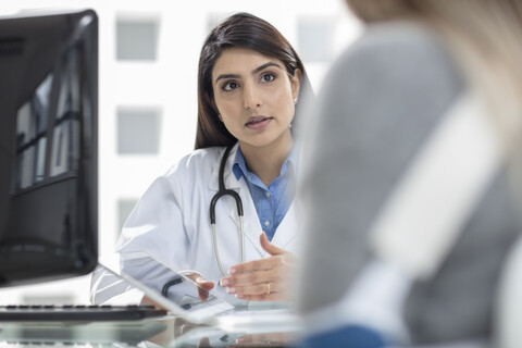 Ärztin im Gespräch mit einem Patienten, lizenzfreies Stockfoto