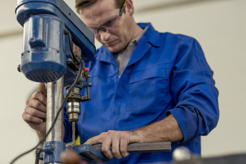 Automechaniker mit Bohrmaschine in einer Werkstatt - ISF02813