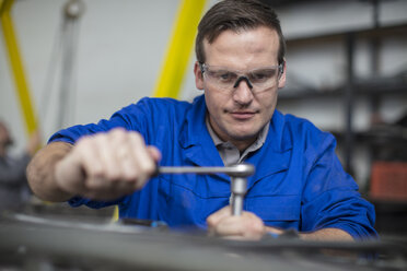 Male car mechanic using wrench in repair garage - ISF02833