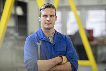 Portrait of male car mechanic with wrench in repair garage - ISF02846