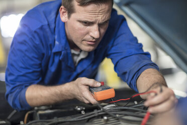 Automechaniker, der den Motor eines Autos in einer Reparaturwerkstatt prüft - ISF02852