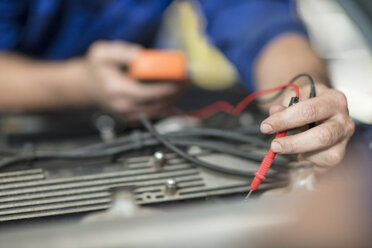 Automechaniker, der den Motor eines Autos in einer Reparaturwerkstatt prüft - ISF02853