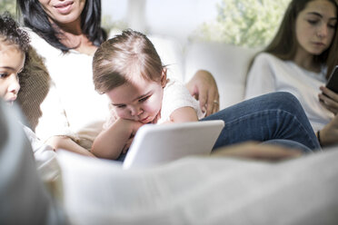 Familie spielt mit digitalem Tablet auf dem Sofa - ISF02865