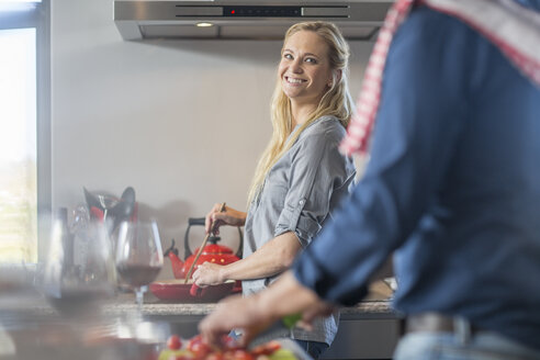 Mann und Frau in der Küche, die Essen zubereiten - ISF02889