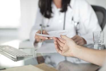 Cropped view of doctor handing patient prescription - ISF02902