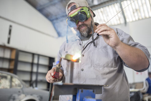 Man welding in bodywork repair shop - ISF02929