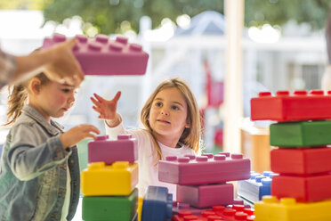 Zwei kleine Kinder, die im Freien mit Schaumstoffbausteinen spielen - ISF02958