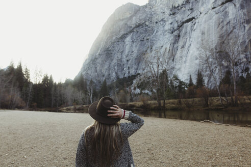 Rückansicht einer Frau mit Hut, die auf einen Berg blickt, Yosemite National Park, Kalifornien, USA - ISF02966