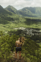 Rear view of woman on grass covered mountain, Oahu, Hawaii, USA - ISF02975