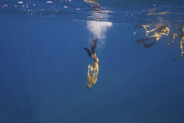 Frauen mit Schwimmflossen schwimmen unter Wasser, Oahu, Hawaii, USA - ISF02977