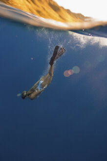 Frau mit Schwimmflossen schwimmt unter Wasser, Oahu, Hawaii, USA - ISF02979