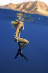 Frau mit Schwimmflossen schwimmt unter Wasser, Oahu, Hawaii, USA - ISF02980