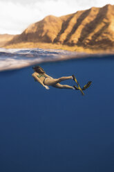 Frau mit Schwimmflossen schwimmt unter Wasser, Oahu, Hawaii, USA - ISF02981