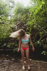 Junge Frau trägt Bikini im Wald und wirft ihr Haar zurück, Oahu, Hawaii, USA - ISF03000