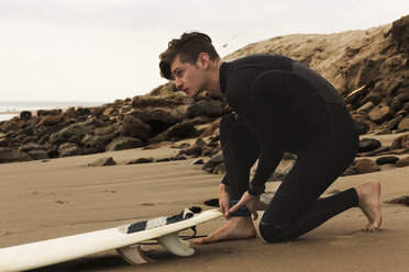 Junger Mann am Strand mit Surfbrett, Vorbereitung zum Surfen - ISF03013