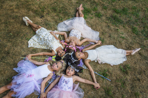 Group of young girls dressed as fairies, lying in circle, heads together - ISF03020