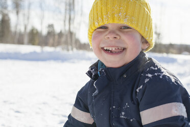 Porträt eines fröhlichen Jungen mit gelber Strickmütze in einer verschneiten Landschaft - ISF03077