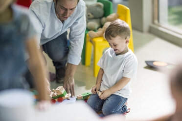 Teacher and boy playing with toy train - ISF03108